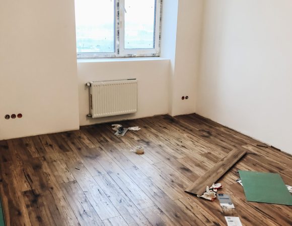 room floor renovation concept. stylish wooden laminate instalation, modern white walls. repairing and working in home, space for text. hardwood plank parquet. renovating